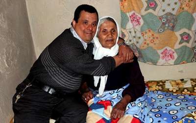Görme engelli yaşlı kadına, down sendromlu oğlu bakıyor