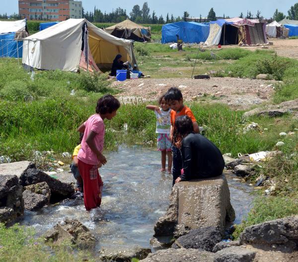 Suriyeli çocukların su birikintisinde serinleme çabası