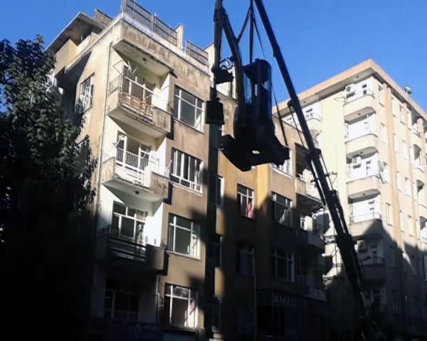Önlem alınmadan kepçeyi vinçle 5 katlı apartmanın terasına çıkardılar