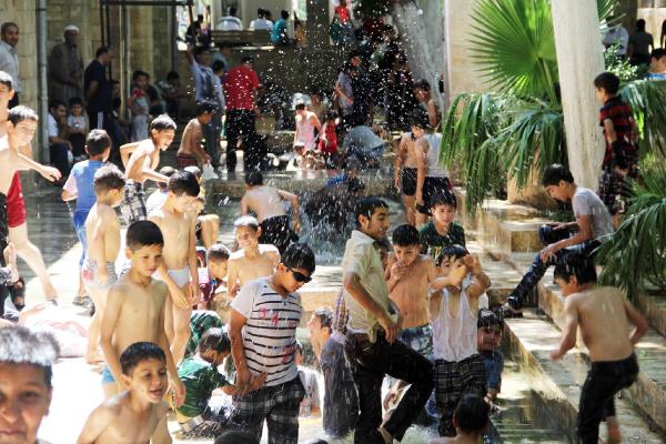 Çocuklar cami avlusundaki kanalda serinledi