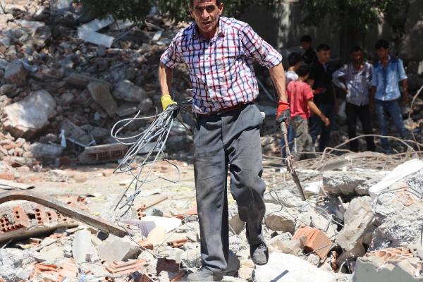 Karakol enkazından hurda demir ve tahta toplamak için yarıştılar