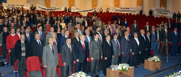 Temel atma töreni boyunca pankartları işçilere tutturdu