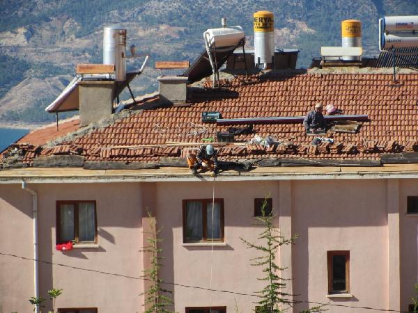 Çatıyı tamir eden işçi, yürükleri ağza getirdi