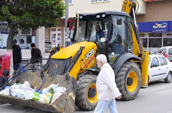 Marketten aldığı malzemeleri kepçeyle taşıdı