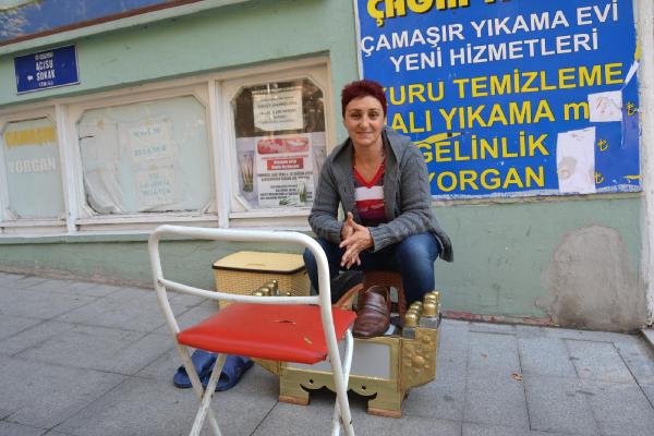 Kızı için ayakkabı boyacılığı yapıyor