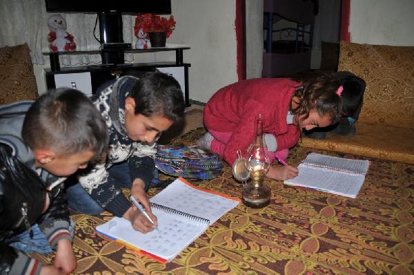 Elektriksiz mezrada öğrenciler mum ışığında ders çalışıyor