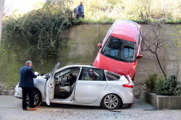 Otomobil, park halindeki otomobilin üzerine düştü