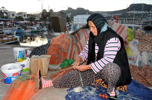 Eşi avlanırken, o ağları tamir ediyor