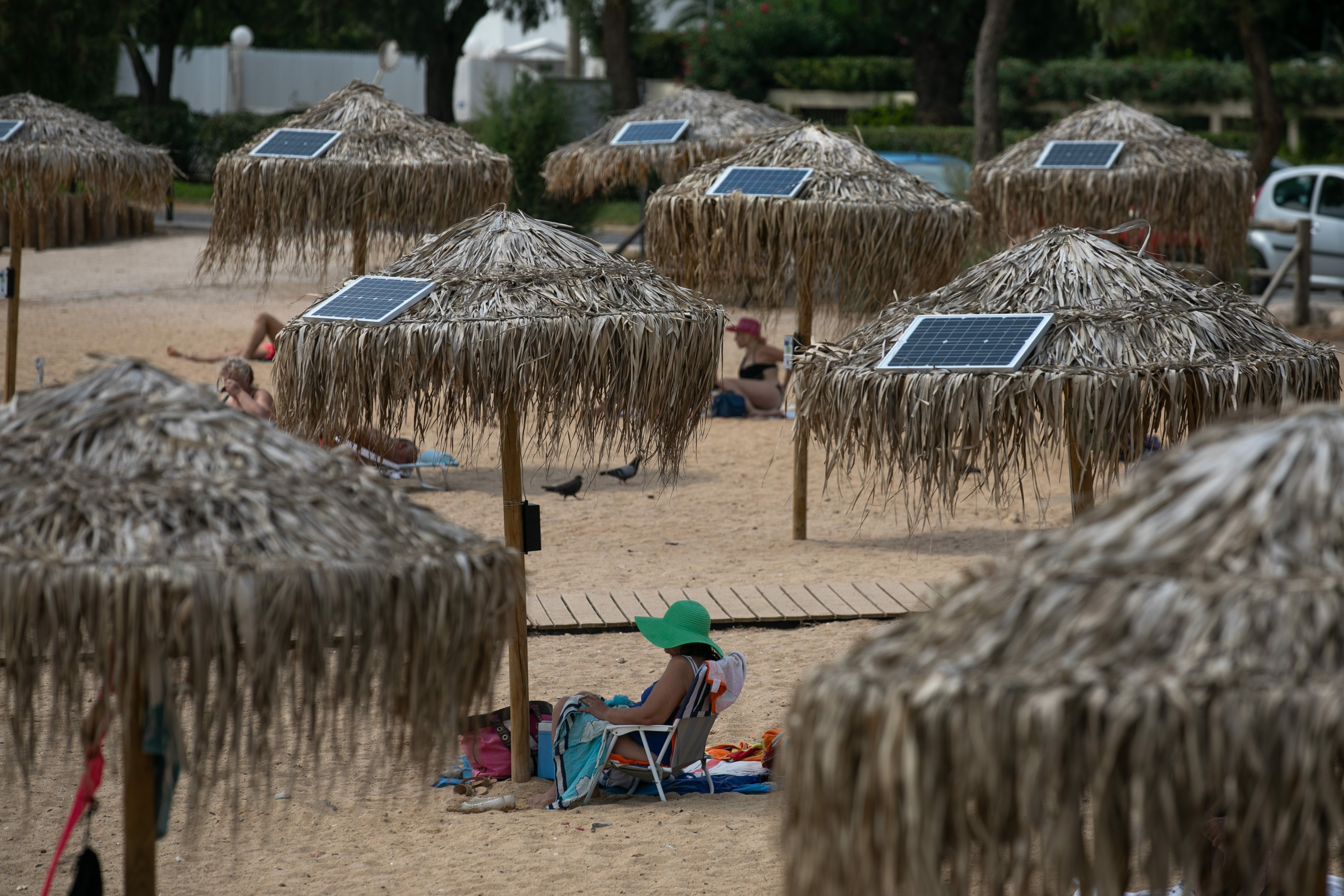 Atina plajlarında güneş enerjili telefon şarj şemsiyeleri